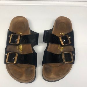 Birkenstock size 8 women’s black patent with gold buckles.